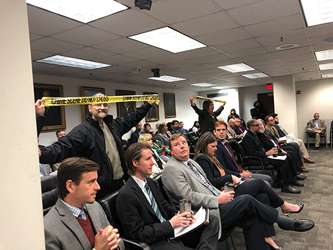Activists with Nuclear Watch South held up CRIME SCENE tape following the PSC vote to support Georgia Power's $7.56 billion rate heist on 12/19/23